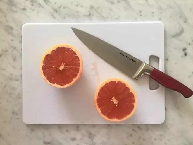 Next, you’re going to squeeze out the fresh grapefruit and add to the mint mixture. Make sure to save some extra pieces of grapefruit to add to your trays to add some flair to your popsicles. 